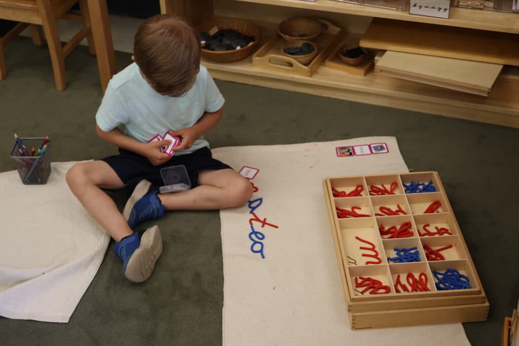 A child works with the Moveable Alphabet material
