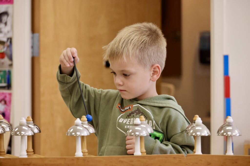 A child working with the Montessori Bells