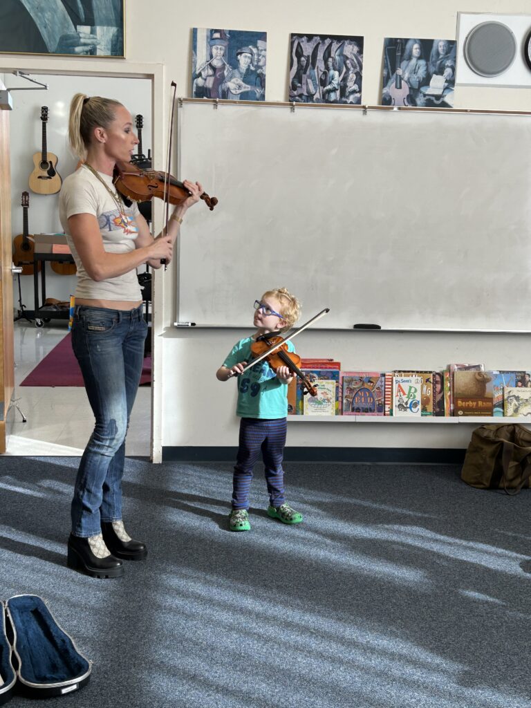 A child learns violin from a teacher