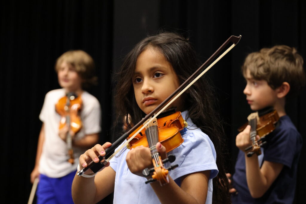 A young student participates in the WMS violin program